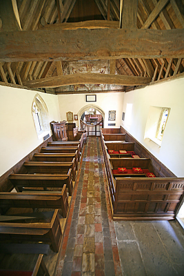 9. Pews and boxed pews, some with re-used 16th century linenfold panelling, flag stoned floor, plastered walls and queen-strut roof.